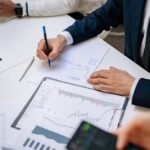 Professionals analyzing financial charts in a corporate setting.