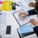 Team reviewing financial charts and digital data on tablets in an office setting.